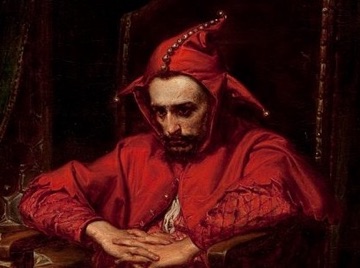 His jester's costume is made for laughs, but his face is grave.